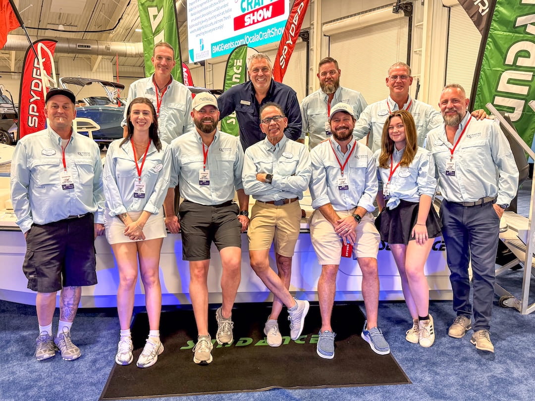 fx marine center staff posing in front of boats at the ocala boat show 2026
